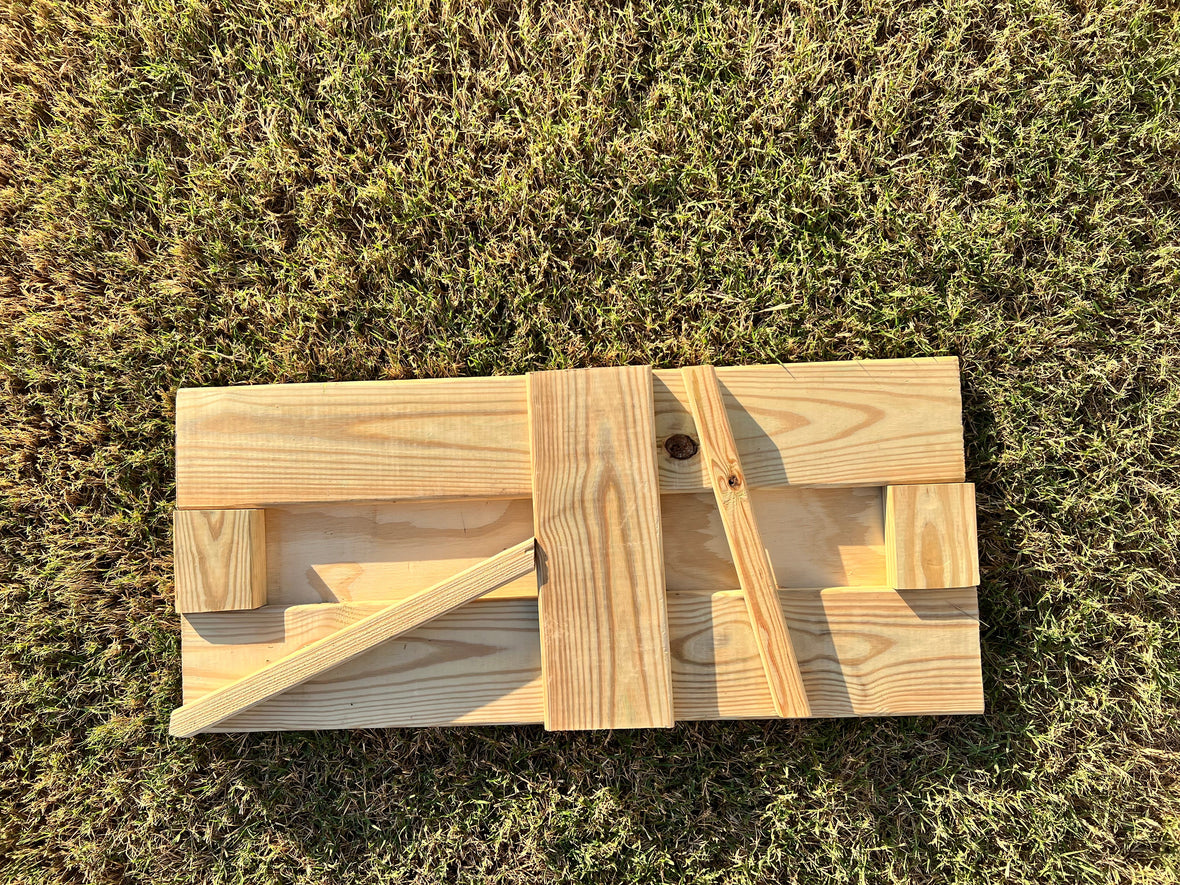 Custom crawl space door laid flat on grass — overhead top-down view during fabrication